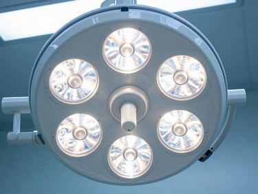 Close-up of a multi-dome surgical LED light array, bright clinical illumination, sterile operating room setup.