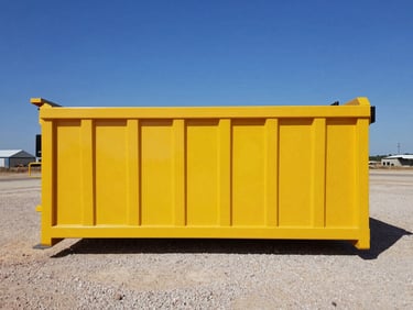 Side-profile product shot of a clean 20-yard yellow roll-off dumpster on gravel, harsh Texas sun.