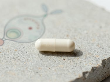 Clean white FemiCore capsule on textured stone, with a subtle scientific illustration of Lactobacillus Crispatus in the background, soft natural daylight.