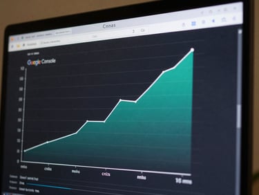 Close-up of a monitor displaying Google Search Console performance chart, showing a clear upward curve in clicks and impressions over six months, teal accent line rising steeply from month three, dark background with data labels visible