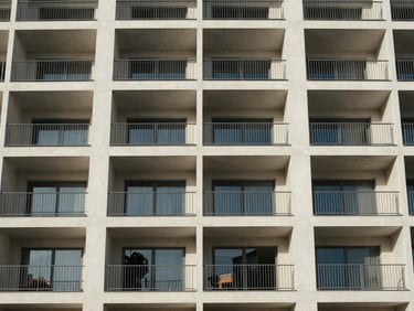 Exterior view of a modern building facade with balconies in the quiet district of Yoff, bright daylight