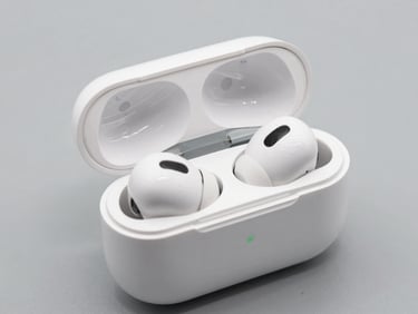 Pair of premium wireless earbuds resting in their charging case, open lid. Bright studio lighting, high-contrast details, neutral background.