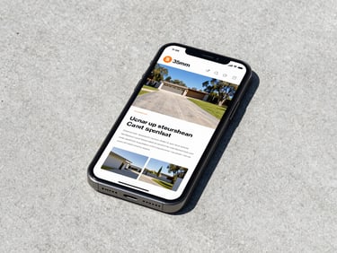 A smartphone displaying a concrete driveway specialist website, resting on a newly poured concrete surface, bright daylight, sharp focus
