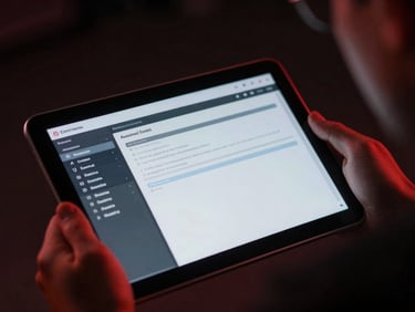 Close-up of a secure tablet displaying a clean technical interface, held by a focused instructor under low-key crimson studio lighting.