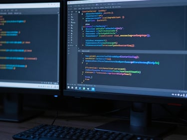 Cool editorial tech photography of clean code on high-contrast monitors with deep slate shadows and sharp electric blue highlights, macro lens, high contrast