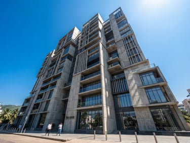 Low-angle architectural perspective of a modern multi-story concrete building facade in Visakhapatnam, bright midday sun, sharp shadows, clear blue sky background.