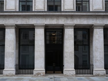Symmetrical modern limestone facade of a financial institution in London, cool overcast daylight, desaturated slate tones, 35mm