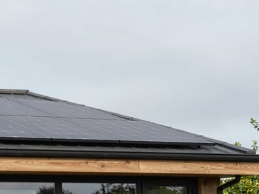 Modern UK roofline with sleek integrated solar photovoltaic panels under a soft grey British sky, architectural elevation, 35mm lens