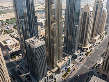 Aerial view of a commercial office district in Business Bay Dubai, glass towers and wide boulevards, midday daylight, no people, wide architectural shot