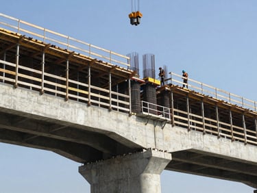 Wide shot of a reinforced concrete bridge abutment under construction, steel rebar cage visible before pour, crane arm overhead, workers in safety gear on scaffolding, harsh direct daylight