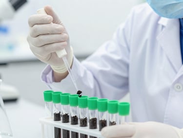 A laboratory technician in a clean white lab coat pipetting soil samples into microcentrifuge tubes, bright sterile white lighting, clinical precision