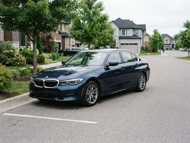 Eye-level three-quarter view of a clean dark blue sedan parked on a quiet, modern suburban street under bright overcast daylight, sharp focus, 50mm lens