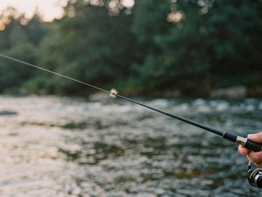 Close-up of a hand-tied fly on a fishing line, with blurred morning river currents in the background, soft golden light.