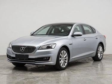 Three-quarter front angle of a silver executive sedan on a matte concrete studio floor, bright even studio lighting revealing clean bodywork and polished trim, close detail on front grille badge and LED headlamps, no people
