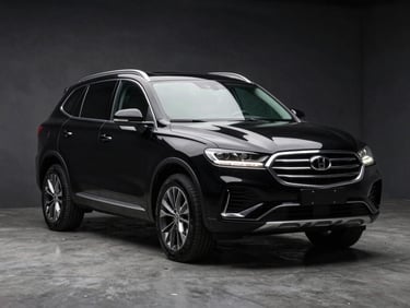 Three-quarter front angle of a black mid-size SUV on a dark concrete studio floor, dramatic overhead lighting highlighting the roofline and front fascia, sharp detail on alloy wheels and fog lights, no people