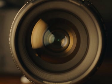 Extreme close-up of an anamorphic camera lens, gold rim light reflecting on glass, cinematic film photography, 35mm style.