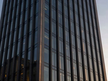 Modern office building facade with sharp geometric glass lines, twilight, architectural photography, 35mm