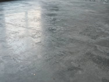 Close up of a polished architectural concrete floor, smooth surface reflecting cold early-morning site light