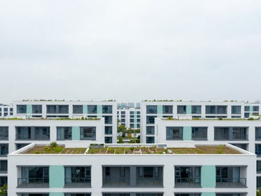 Architectural shot of a modern sustainable residential district, clean lines, integrated green roofs, bright overcast daylight.