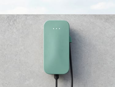Minimalist detail of a modern electric vehicle charging station mounted on a concrete wall, clean architectural photography, sage green accent.