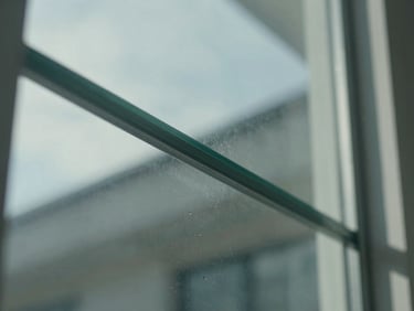 Macro close-up of a perfectly streak-free, clear glass pane reflecting bright clinical daylight, sharp geometric lines.