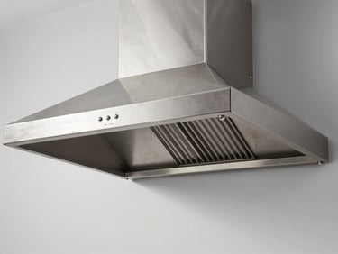 Straight-on shot of a gleaming industrial stainless steel kitchen hood, reflecting clean studio lighting with zero grease.