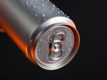 Close-up of a matte aluminum can with neon orange rim lighting, floating in dark studio space with condensation droplets, macro 100mm