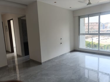Spacious empty apartment room with polished grey marble flooring and a large window.