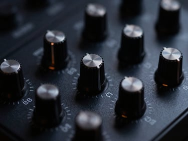 Macro shot of a dark audio application interface, glowing knobs, metallic dials, deep charcoal background.