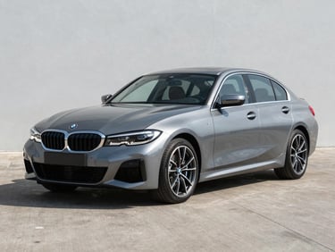 2021 BMW 3 Series grey sedan photographed three-quarter front on clean tarmac, bright daylight, no people, full vehicle clearly visible
