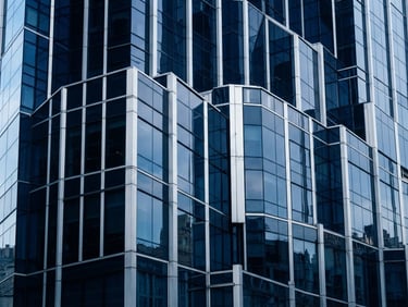 Architectural abstract lines of a modern skyscraper facade reflecting cool morning daylight, deep navy glass panels, silver steel structures, sharp focus, 35mm