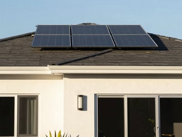 A clean modern house exterior showing crisp paint lines and solar panels on a dark roof, bright afternoon sun