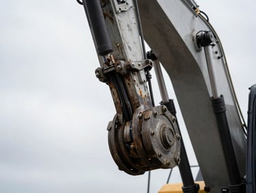 Macro detail shot of a heavy excavator's hydraulic arm joint, showing grease and wear, high-contrast overcast daylight, gritty industrial photography.