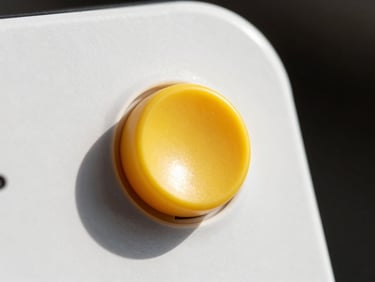 Macro shot of a bright yellow slider button on a clean white UI, cast shadow on a sunny day