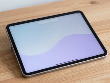 Close-up of a sleek, minimalist smart tablet displaying a clean digital interface on a wooden desk.