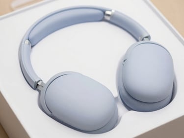 Close-up of sleek modern noise-cancelling headphones in minimalist packaging, soft daylight.