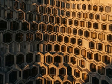 Sharp high-angle architectural shot of a modern concrete building facade with repeating hexagonal window patterns, golden hour directional light casting long geometric shadows, 35mm.