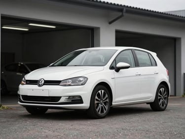 Realistic unedited outdoor photo of a clean white compact hatchback car parked in front of the garage under overcast daylight, no filters.