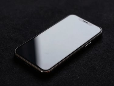 Smartphone lying on black seamless surface, screen intact and reflective under directional strobe light, protective film texture visible at the edge, zero cracks, forensic macro style