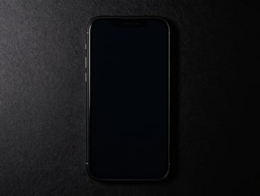 Overhead straight-down shot of a phone on black seamless, screen lit by side strobe, film layer visible with zero impact marks, forensic clarity, no lifestyle elements