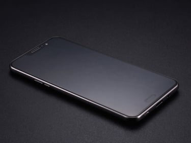 Samsung Galaxy screen face-up on black background, intact display under hard studio strobe, blindagem film edge visible, no scratches, high-contrast forensic product shot