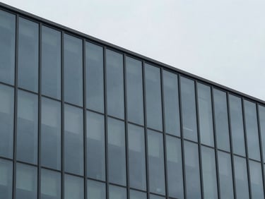 Abstract geometric pattern of glass facade panels under a slate gray sky, sharp focus, desaturated tones