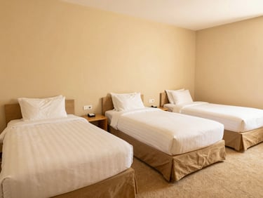Spacious triple guest room with three neatly made single beds, warm sand tones, welcoming hospitality setup, 35mm lens