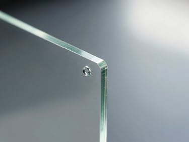 Tight close-up of a polished clear acrylic sheet edge showing optical clarity and machined finish under cool daylight