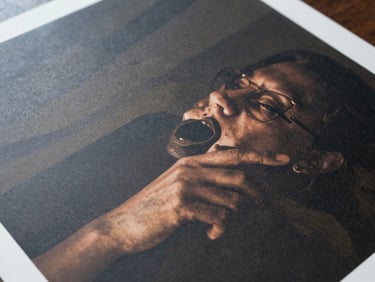 Tight overhead close-up of a freshly printed large-format vinyl banner surface, showing saturated ink detail and weave texture under cool studio daylight
