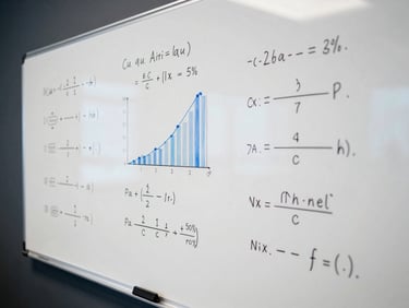 Close-up of a clean whiteboard covered in mathematical formulas and sales performance charts under cool office daylight