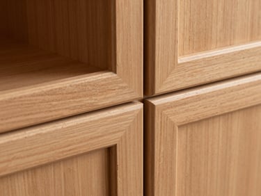 Macro detail shot of a solid maple cabinet door corner, showing precise mortise-and-tenon joinery, smooth matte paint finish, and crisp architectural shadow.