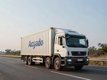 Wide shot of a modern branded closed-container cargo truck driving on a clean Indian national highway under bright morning sunlight, clear skies, spacious composition.