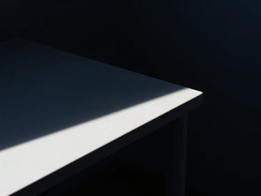 Minimalist workspace detail, sharp architectural shadows, cool navy undertones, high-contrast cinematic lighting