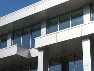 Close-up architectural detail of modern commercial building facade in Lehi Utah, steel and glass panels, crisp daylight, sharp geometric shadows